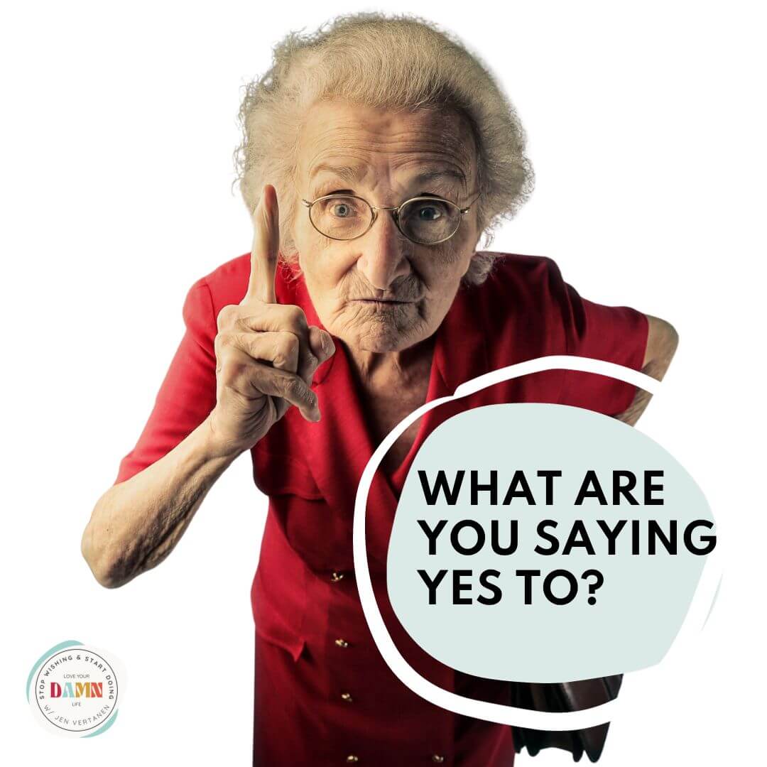 A slightly stern but funny older woman in a red dress with her pointer finger raised and a blue circle with the words What Are You Saying Yes To with Life Design Coach Jen Vertanen