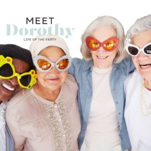 A group of 4, smiling older women all wearing funny sunglasses with the words Meet Dorothy - Life of the Party