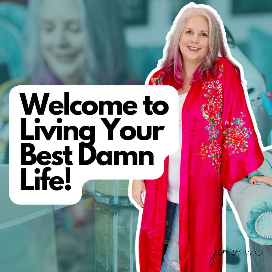 Jen Vertanen, smiling woman with gray and pink hair, wearing vibrant red floral kimono. Text overlay: 'Welcome to Living Your Best Damn Life!' Background shows teal furniture and blurred image of Jen